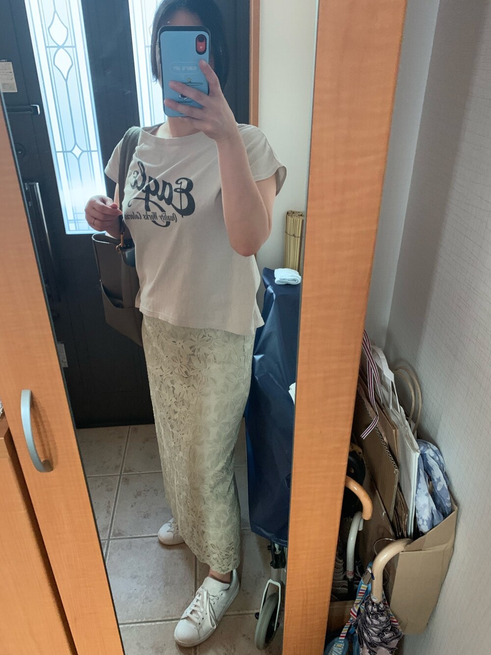 グレー系のTシャツ/カットソー、グリーン系のスカート、ホワイト系のスニーカーを着用したレディースの夏コーディネートの1枚目の写真