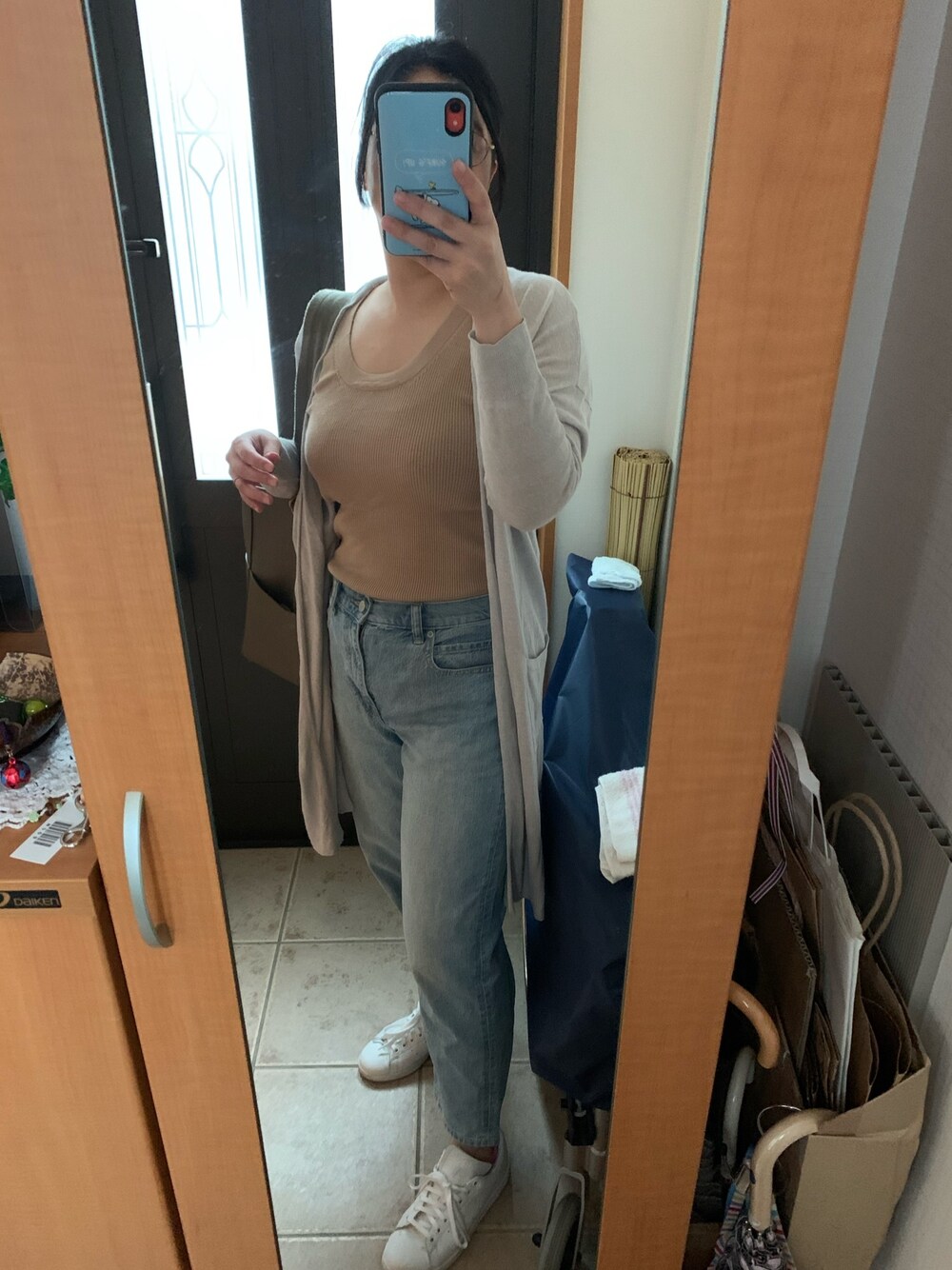 ブルー系のデニムパンツ、グレー系のカーディガン/ボレロ、ベージュ系のタンクトップを着用したレディースの夏コーディネートの1枚目の写真