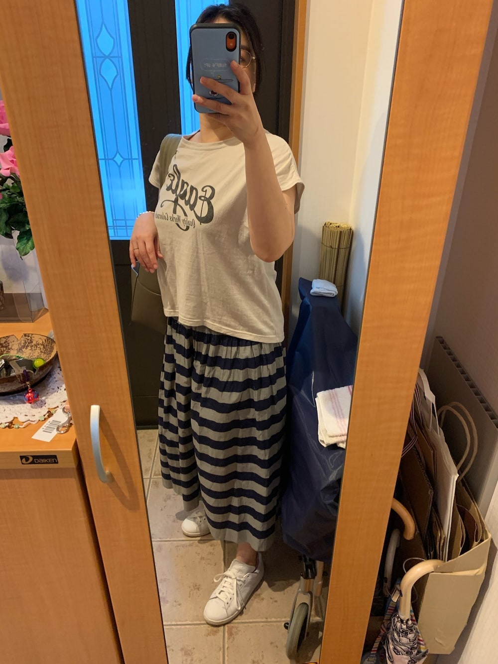 グレー系のTシャツ/カットソー、ブルー系のスカート、ホワイト系のスニーカーを着用したレディースの夏コーディネートの1枚目の写真