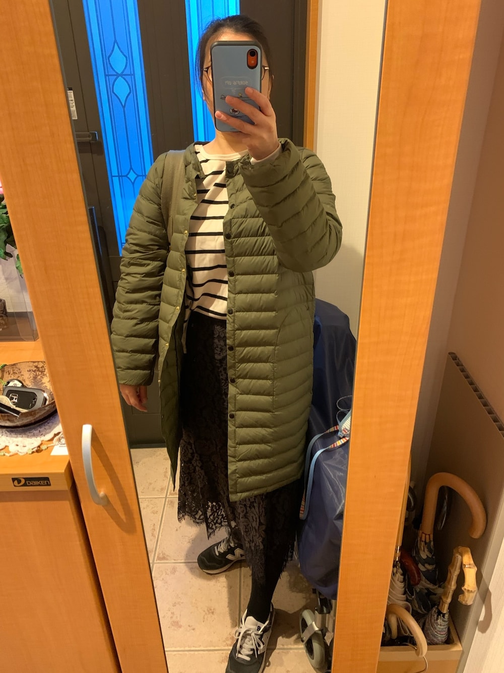 グリーン系のダウンジャケット/コート、ブラック系のTシャツ/カットソー、グレー系のスカートを着用したレディースの秋コーディネートの1枚目の写真