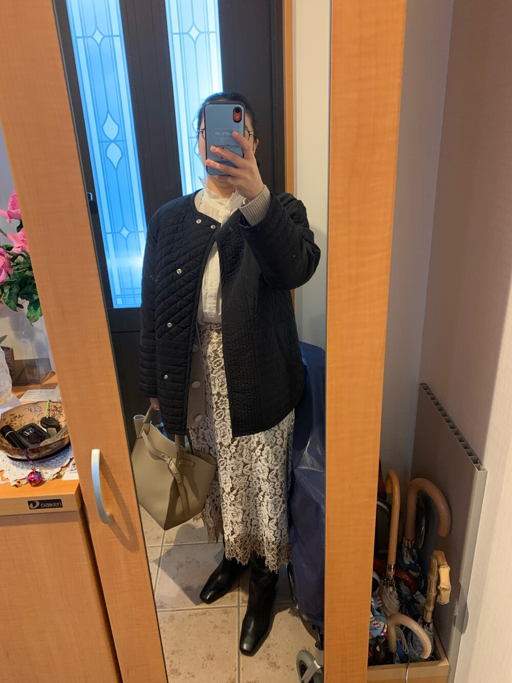 ブラック系のブルゾン、ベージュ系のカーディガン/ボレロ、ホワイト系のシャツ/ブラウスを着用したレディースの冬コーディネートの1枚目の写真