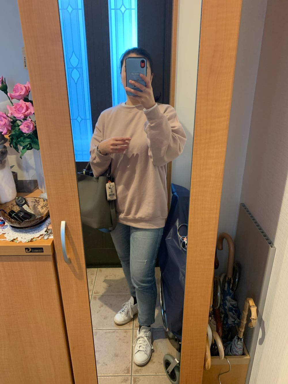 ピンク系のスウェット、ホワイト系のTシャツ/カットソー、ブルー系のデニムパンツを着用したレディースの冬コーディネートの1枚目の写真