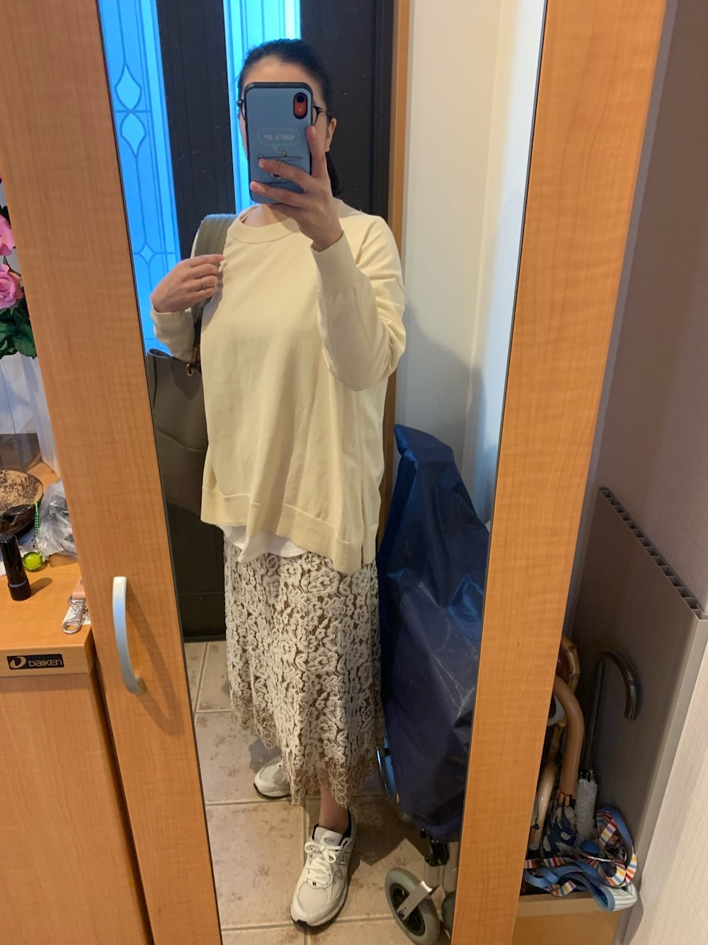 ベージュ系のニット/セーター、ホワイト系のTシャツ/カットソー、ベージュ系のスカートを着用したレディースの春コーディネートの1枚目の写真