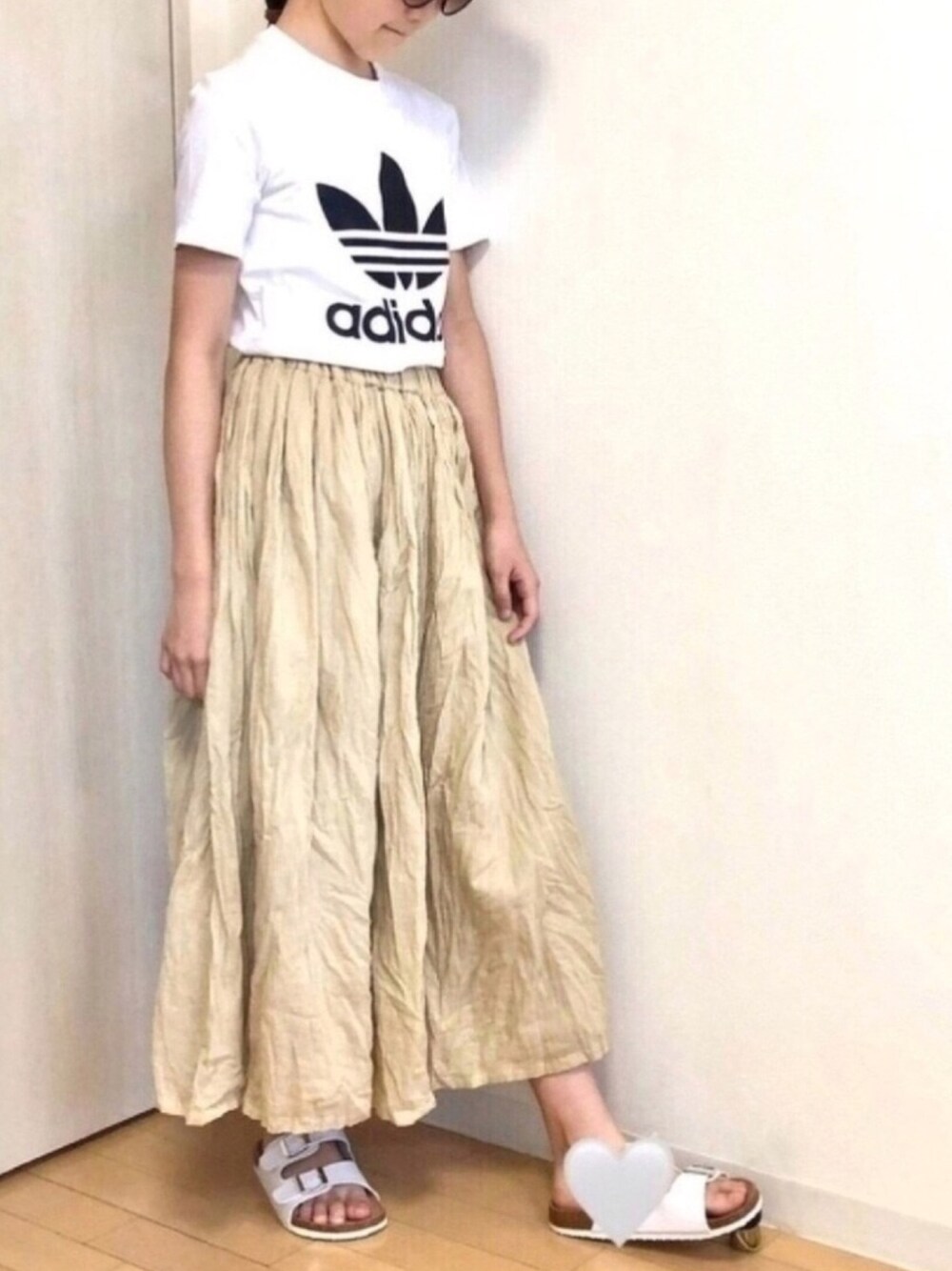 ホワイト系のTシャツ/カットソー、ベージュ系のスカート、ベージュ系のキャップを着用したキッズの夏コーディネートの1枚目の写真