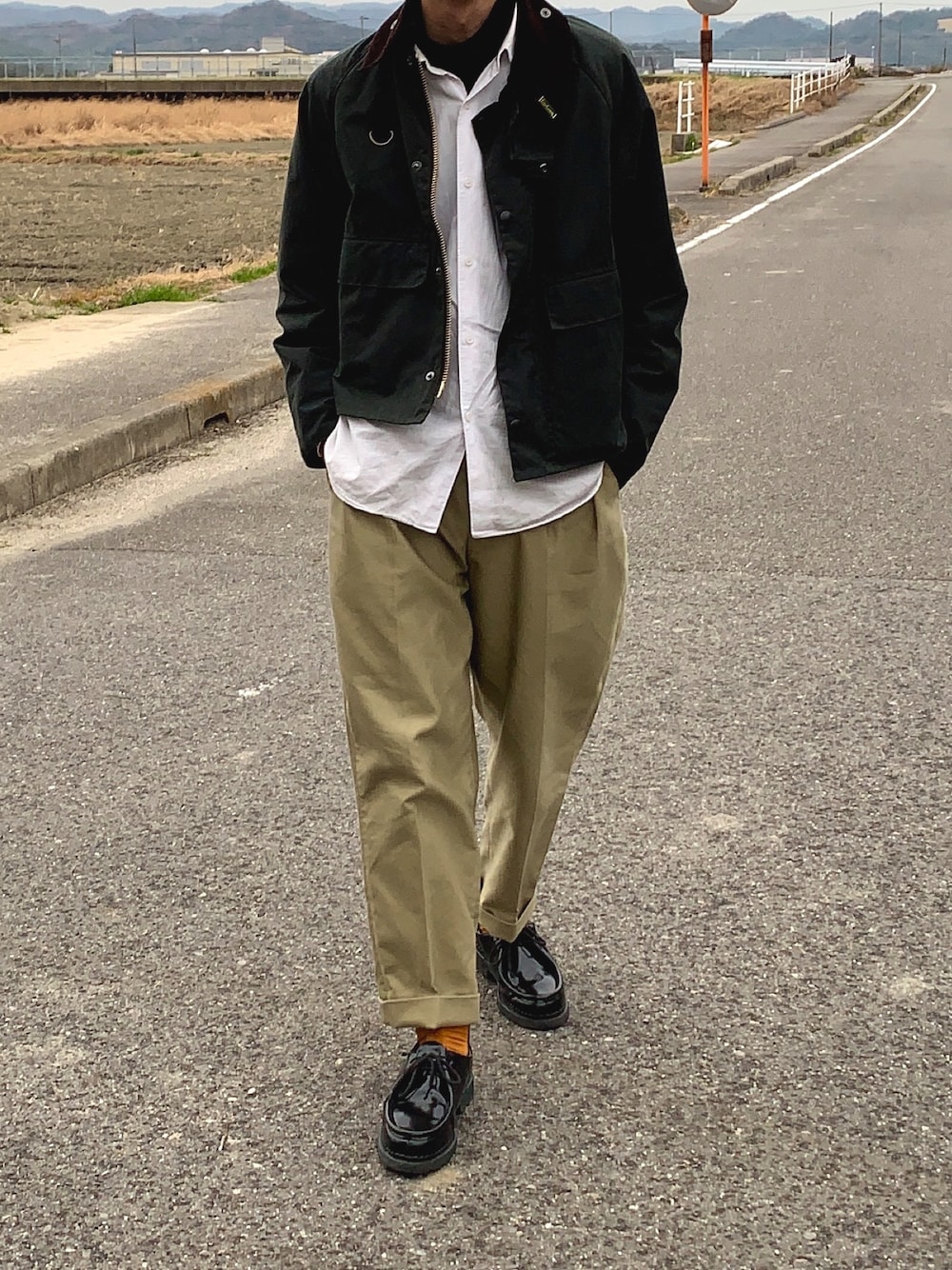 グリーン系のその他アウター、ホワイト系のシャツ/ブラウス、ベージュ系のスラックスを着用したメンズの冬コーディネートの1枚目の写真