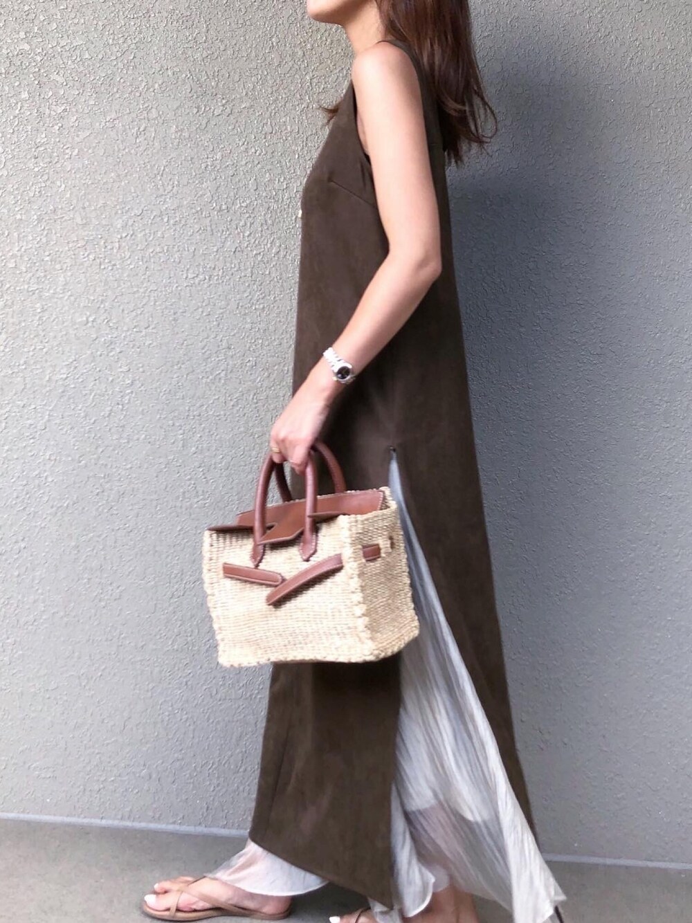 グリーン系のワンピース、グリーン系のスカート、ベージュ系のかごバッグを着用したレディースの夏コーディネートの1枚目の写真