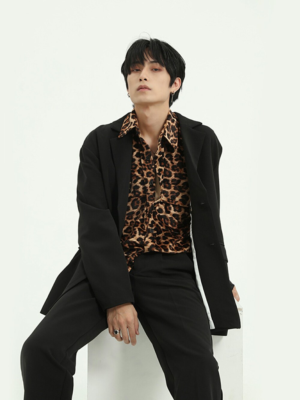 ブラック系のテーラードジャケット、ブラック系のチノパンツを着用したメンズの冬コーディネートの1枚目の写真