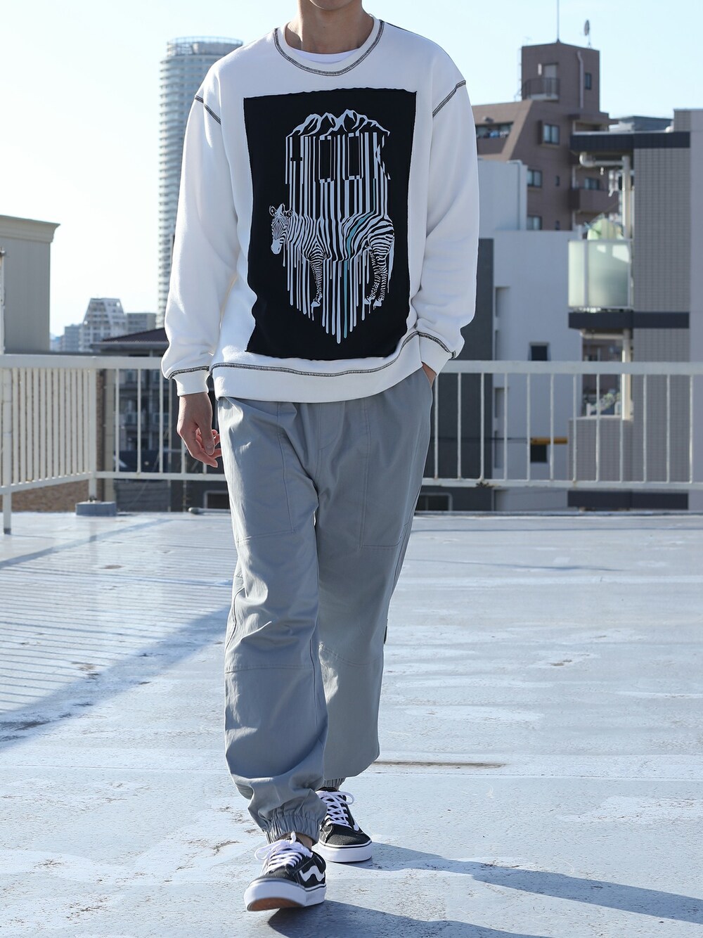 ブラック系のスウェット、ブルー系のスニーカーを着用したメンズの秋コーディネートの1枚目の写真