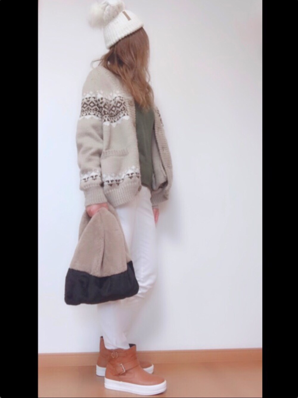 グリーン系のニット/セーター、ホワイト系のデニムパンツ、ブラウン系のブーツを着用したレディースの秋コーディネートの1枚目の写真