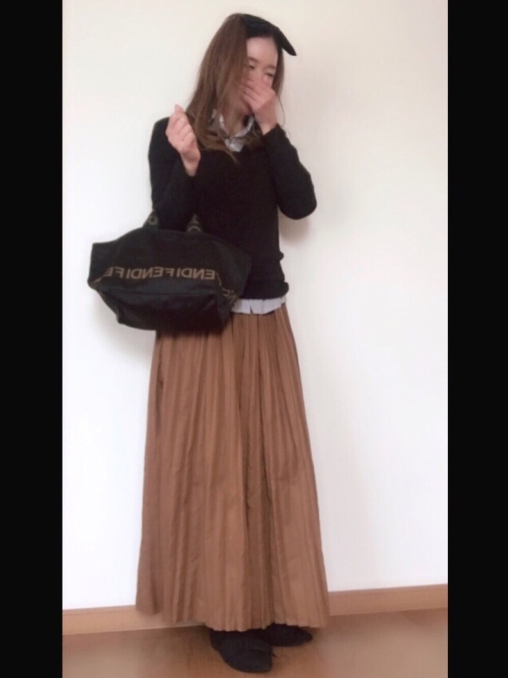 ブラック系のニット/セーター、ブラック系のシャツ/ブラウス、ブラック系のスカートを着用したレディースの秋コーディネートの1枚目の写真