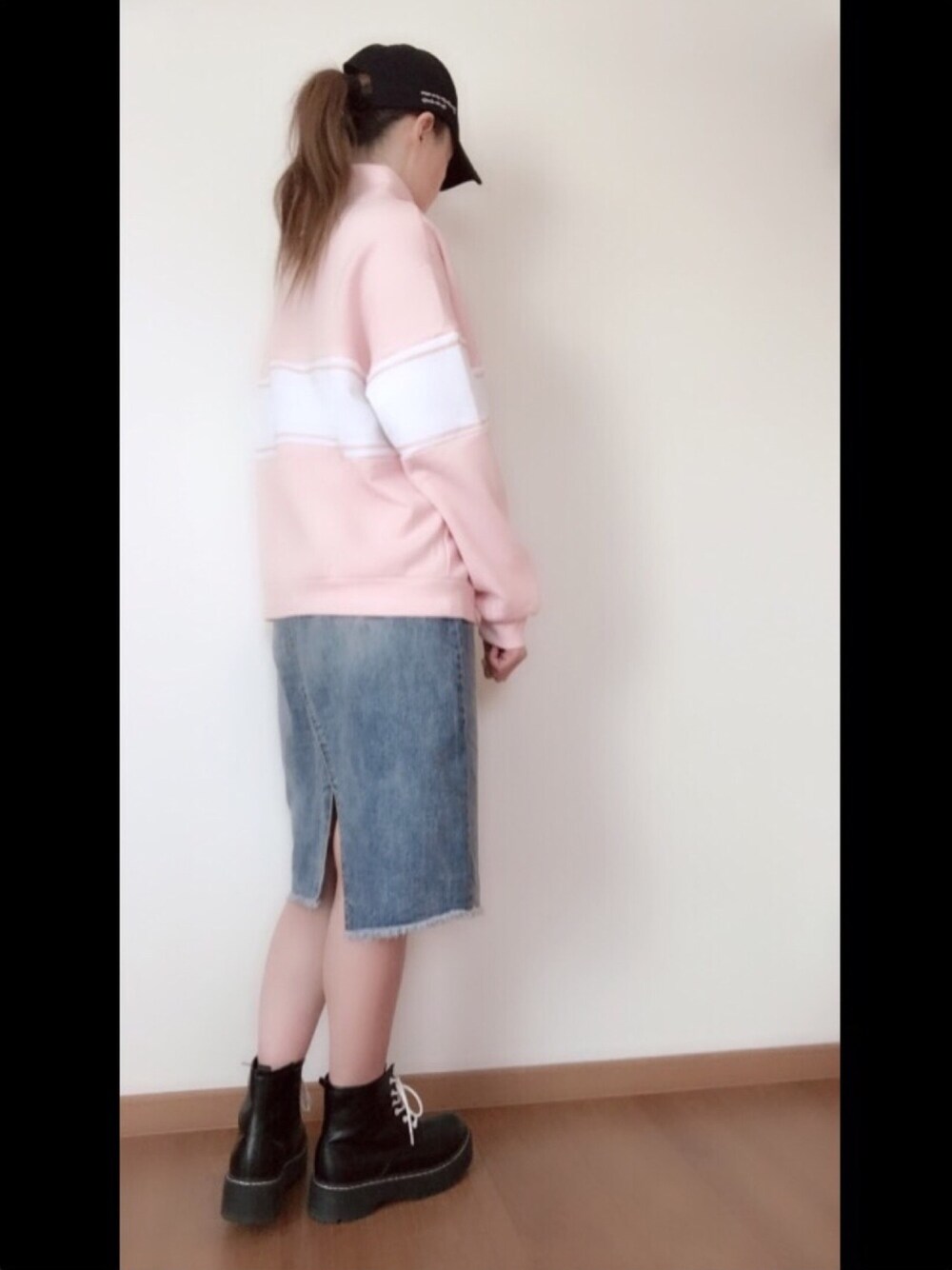 ブルー系のデニムスカート、ピンク系のスウェット、ブラック系のブーツを着用したレディースの冬コーディネートの1枚目の写真