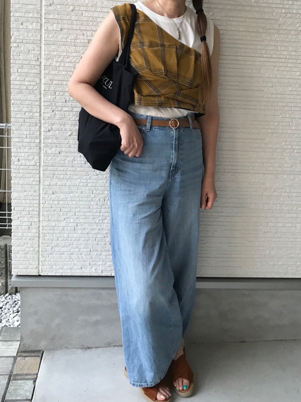 ブルー系のデニムパンツ、ブラウン系のTシャツ/カットソー、ブラック系のエコバッグ/サブバッグを着用したレディースの夏コーディネートの1枚目の写真