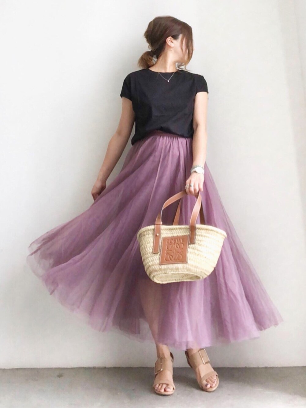 ベージュ系のバッグ、ピンク系のスカート、ブラック系のTシャツ/カットソーを着用したレディースの春コーディネートの1枚目の写真