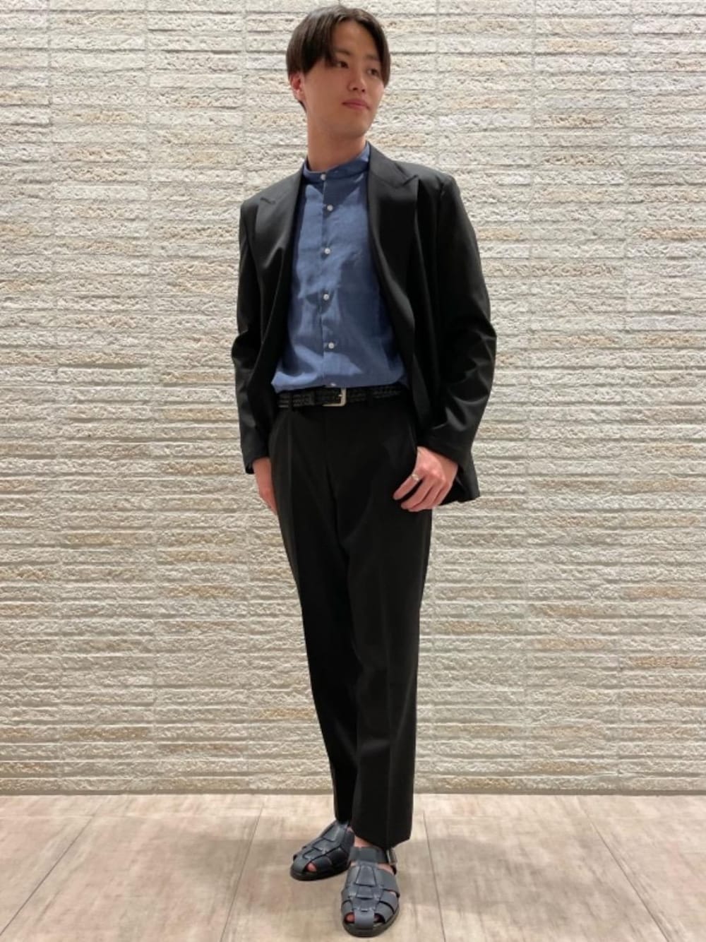 ブルー系のサンダル、ブラック系のテーラードジャケット、ブルー系のビジネスシャツを着用したメンズの夏コーディネートの1枚目の写真