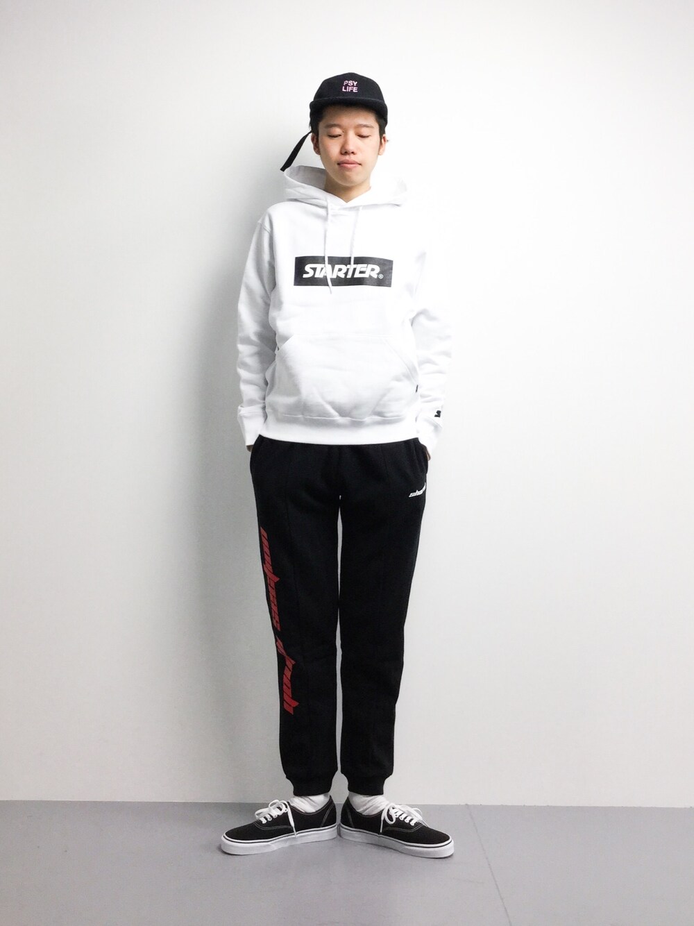 ホワイト系のパーカー、ブラック系のその他パンツ、ブラック系のスニーカーを着用したメンズの春コーディネートの1枚目の写真