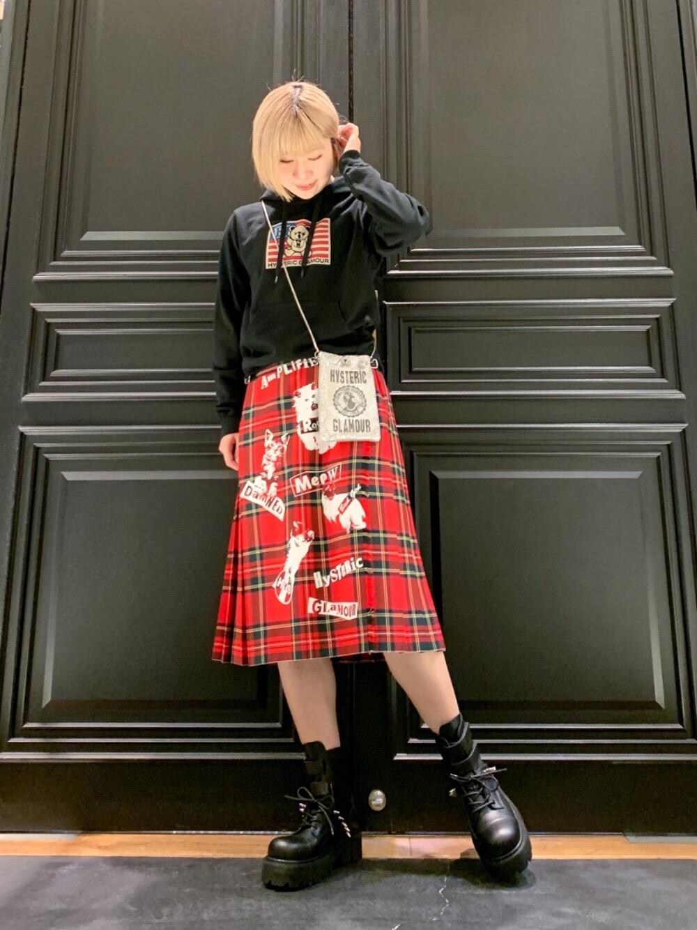 レッド系のスカート、シルバー系のショルダーバッグ、ブラック系のパーカーを着用したレディースの冬コーディネートの1枚目の写真