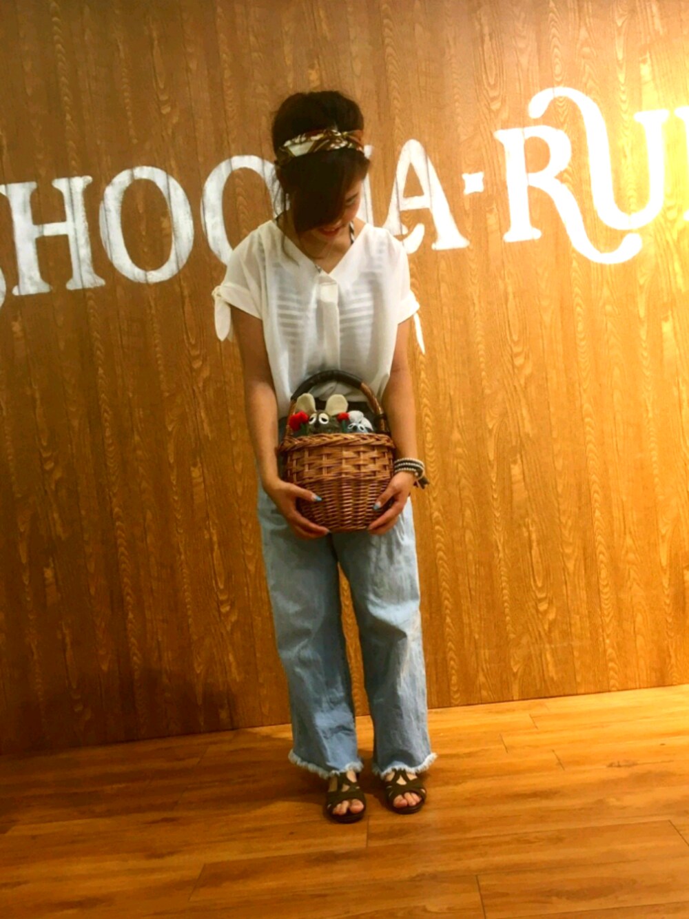 ホワイト系のTシャツ/カットソー、ブラウン系のハンドバッグ、ブルー系のデニムパンツを着用したレディースの夏コーディネートの1枚目の写真