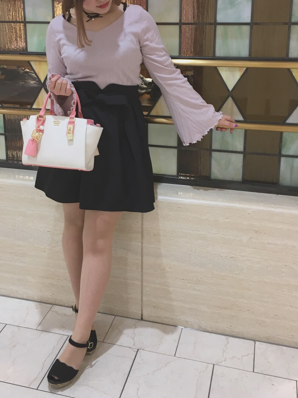ホワイト系のハンドバッグ、ピンク系のTシャツ/カットソー、ブラック系のサンダルを着用したレディースの春コーディネートの1枚目の写真