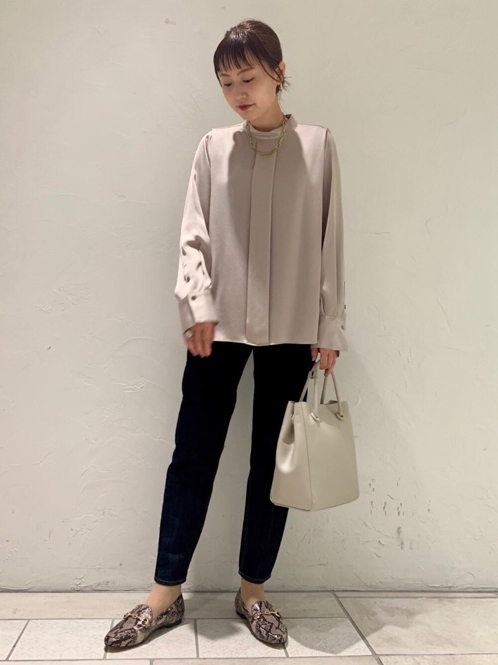 ブルー系のデニムパンツ、グレー系のショルダーバッグ、その他のローファーを着用したレディースの夏コーディネートの1枚目の写真
