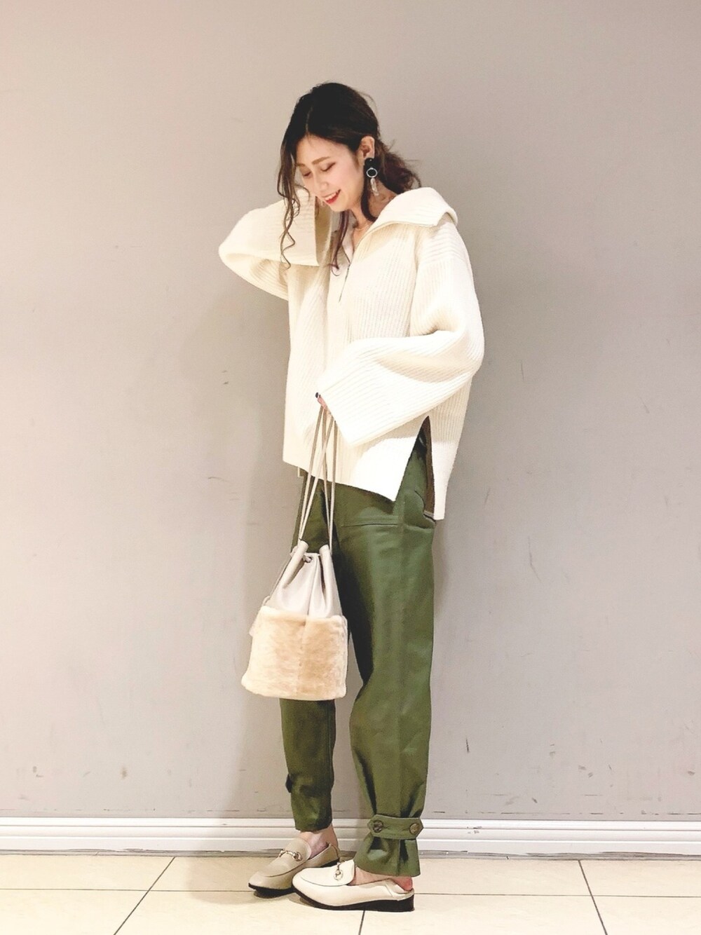 ホワイト系のニット/セーター、グリーン系のその他パンツ、ベージュ系のトートバッグを着用したレディースの冬コーディネートの1枚目の写真