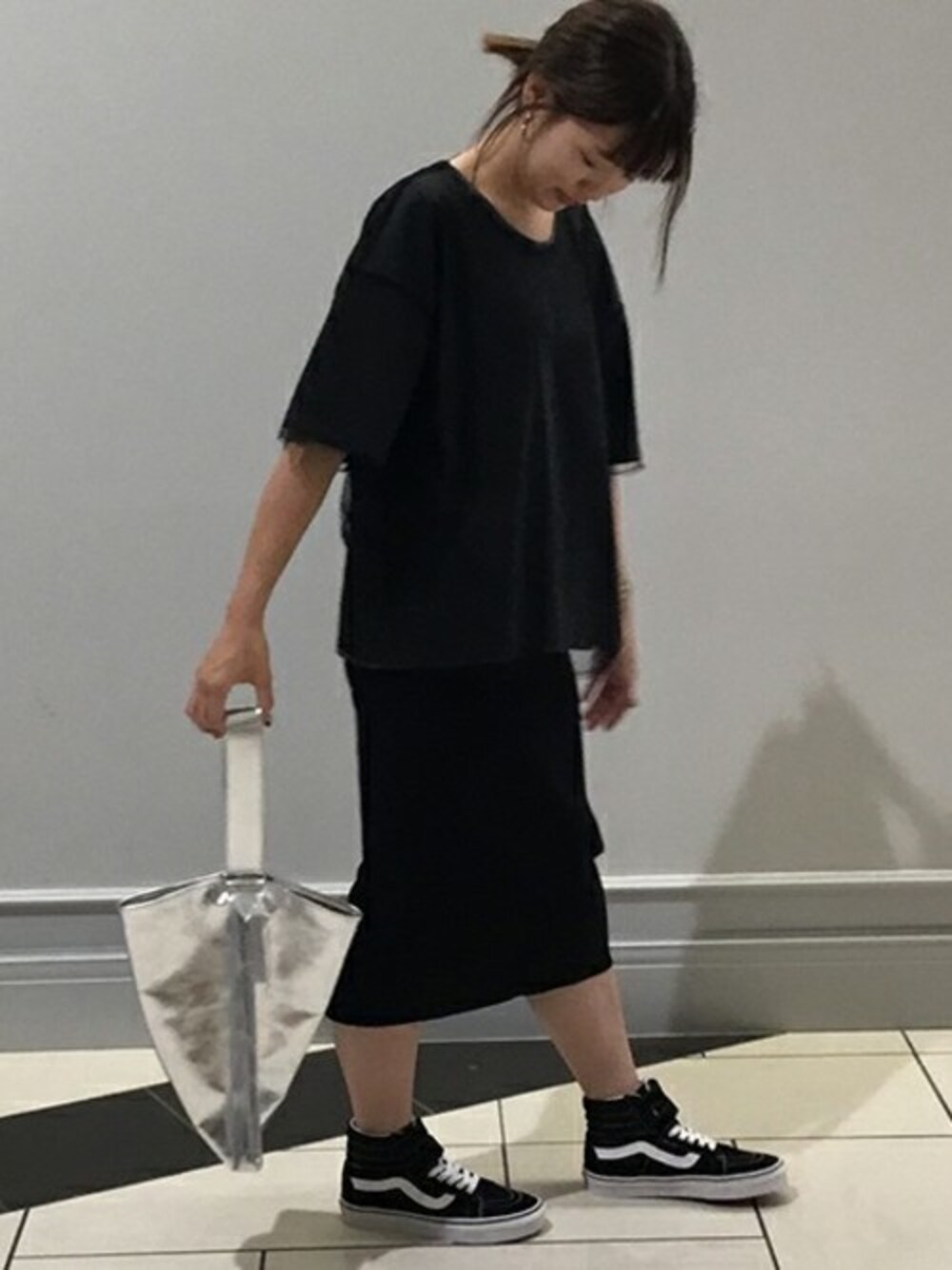 ブラック系のTシャツ/カットソー、シルバー系のハンドバッグ、ブラック系のスニーカーを着用したレディースの夏コーディネートの1枚目の写真