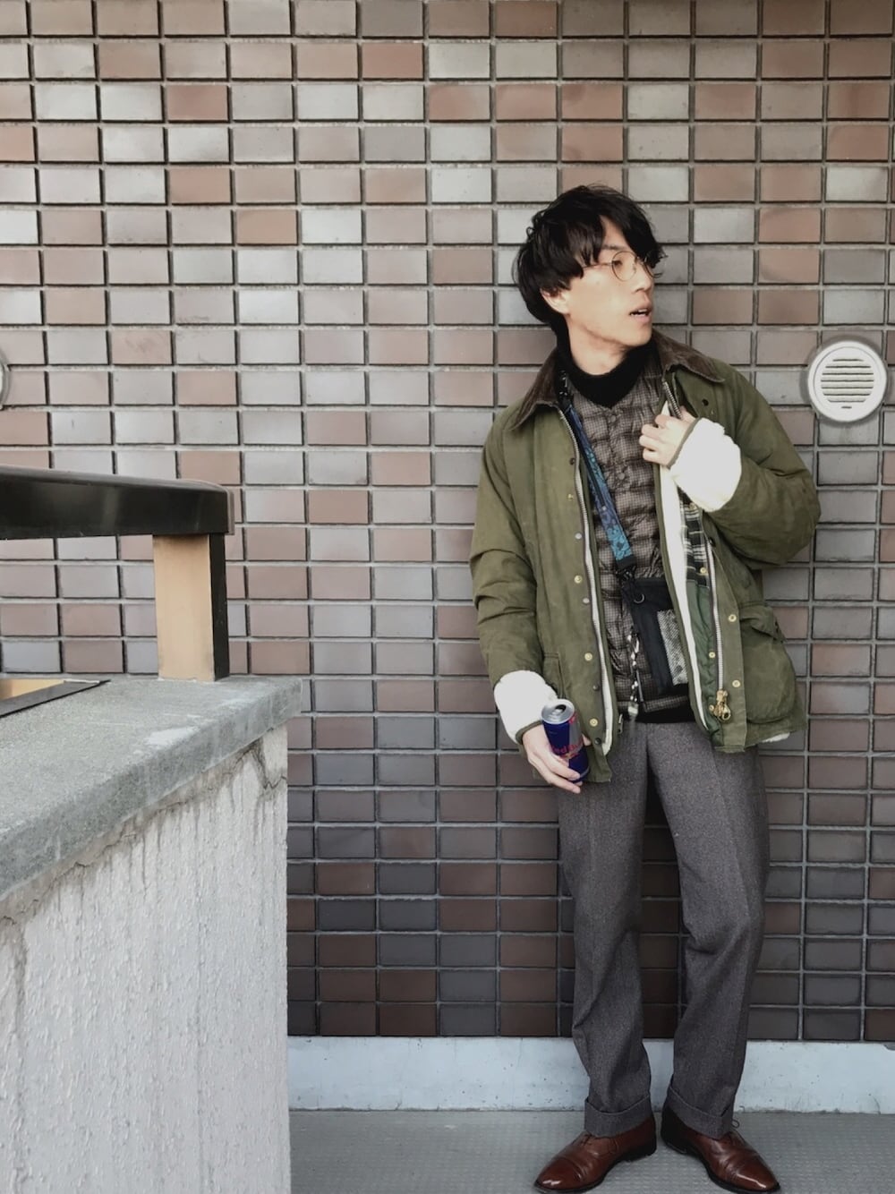 ブラック系のボディバッグ/ウエストポーチ、グリーン系のブルゾン、ブラウン系のスラックスを着用したメンズの冬コーディネートの1枚目の写真