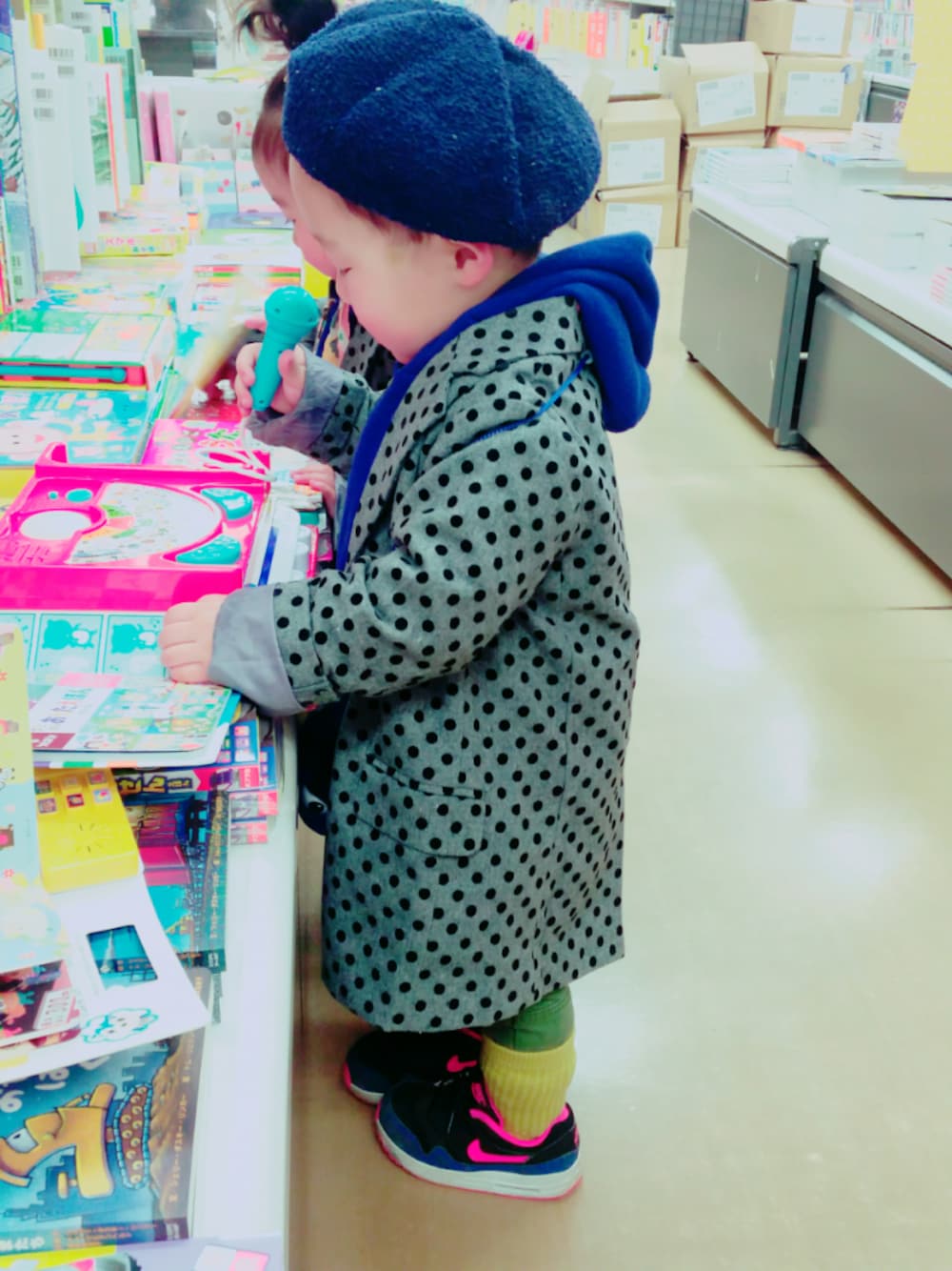 グレー系のチェスターコート、ブラック系のスニーカー、ブルー系のパーカーを着用したキッズの春コーディネートの1枚目の写真