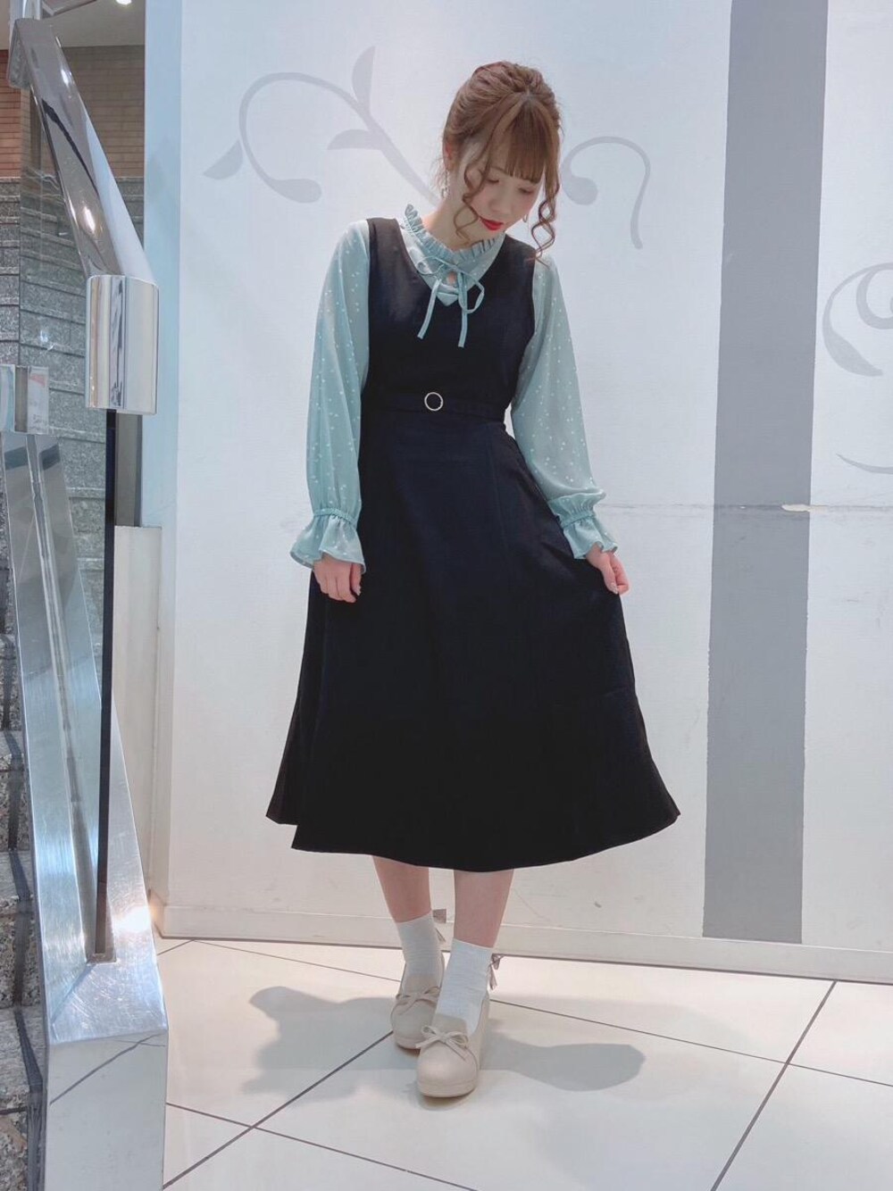 ホワイト系のパンプス、グリーン系のシャツ/ブラウスを着用したレディースの春コーディネートの1枚目の写真