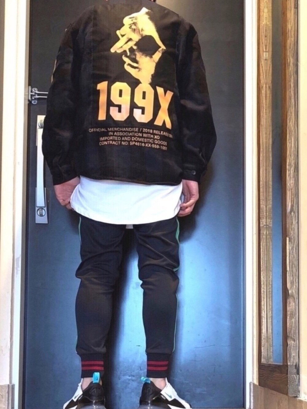 ホワイト系のTシャツ/カットソー、ホワイト系のスニーカー、ブラック系のパンツを着用したメンズの春コーディネートの1枚目の写真