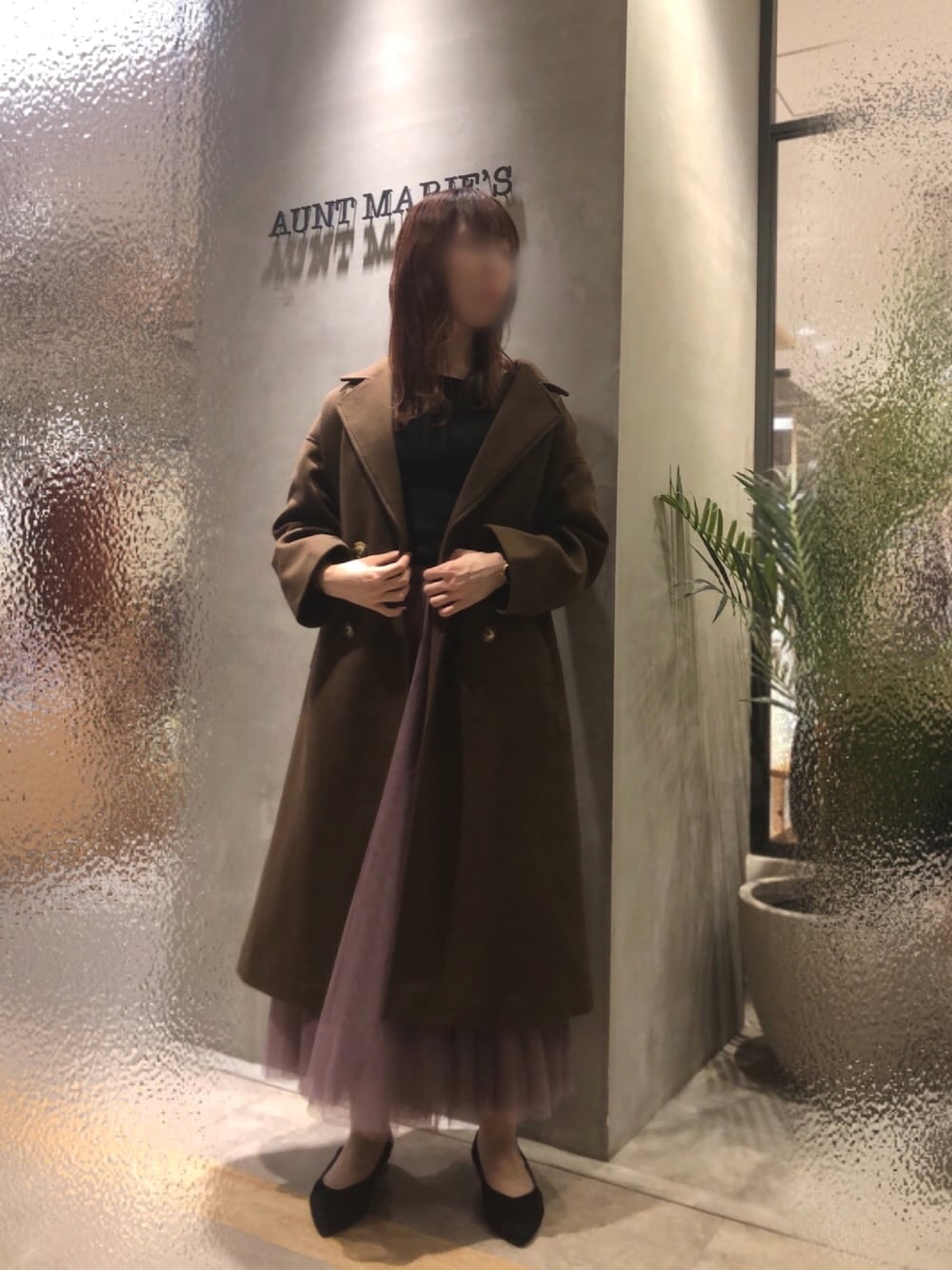 ピンク系のスカート、ブラウン系のチェスターコートを着用したレディースの秋コーディネートの1枚目の写真