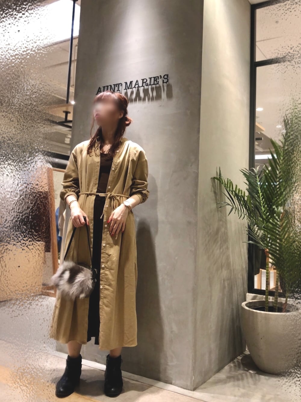 ベージュ系のワンピース、ブラウン系のスカートを着用したレディースの秋コーディネートの1枚目の写真