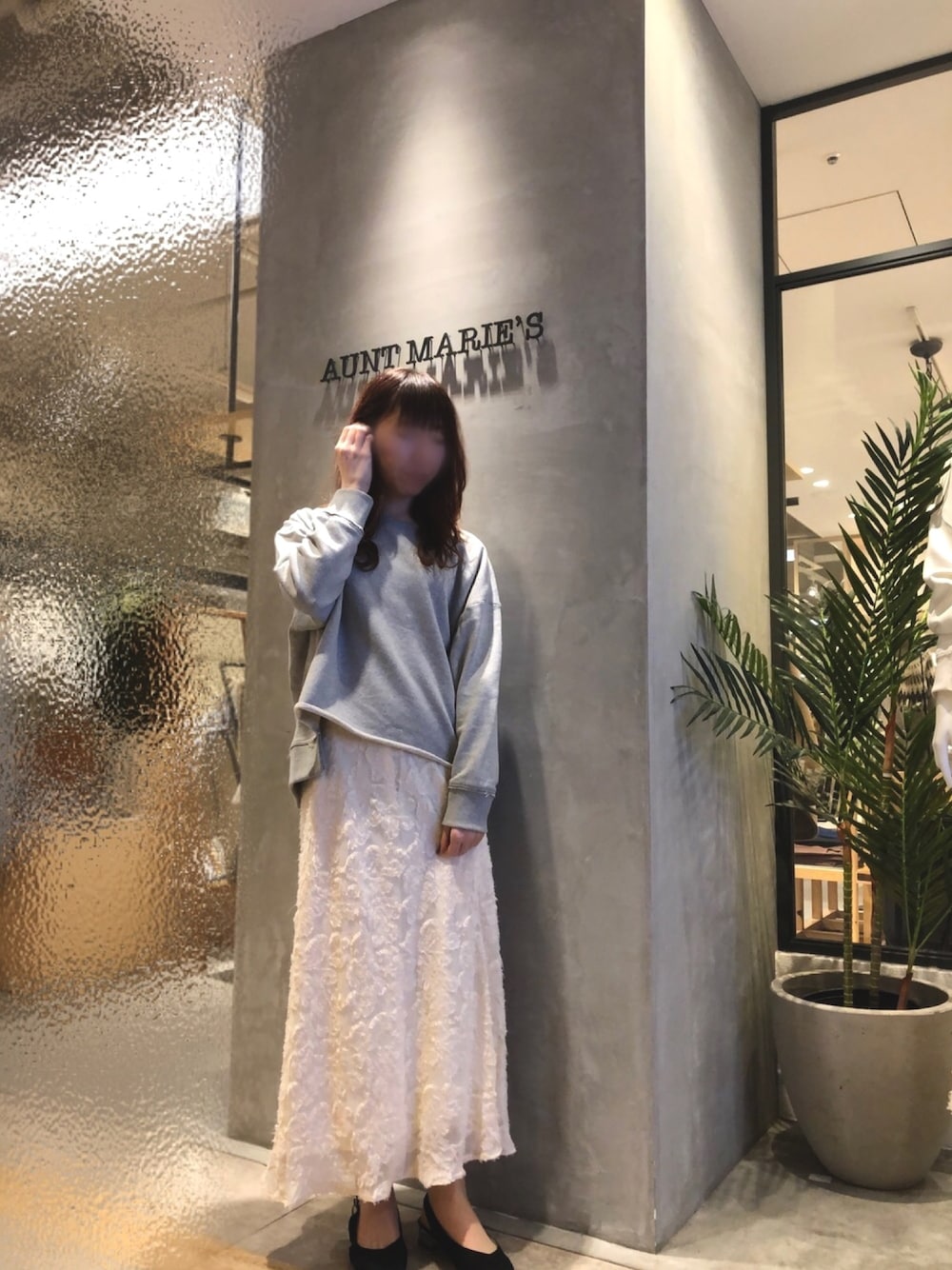 グレー系のスウェット、ベージュ系のスカートを着用したレディースの冬コーディネートの1枚目の写真