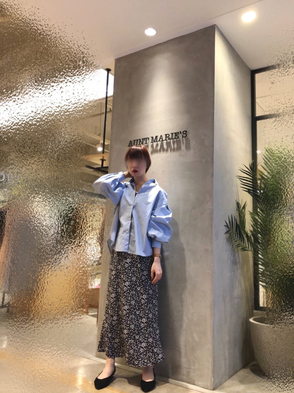 ブラック系のスカート、ブルー系のシャツ/ブラウスを着用したレディースの春コーディネートの1枚目の写真