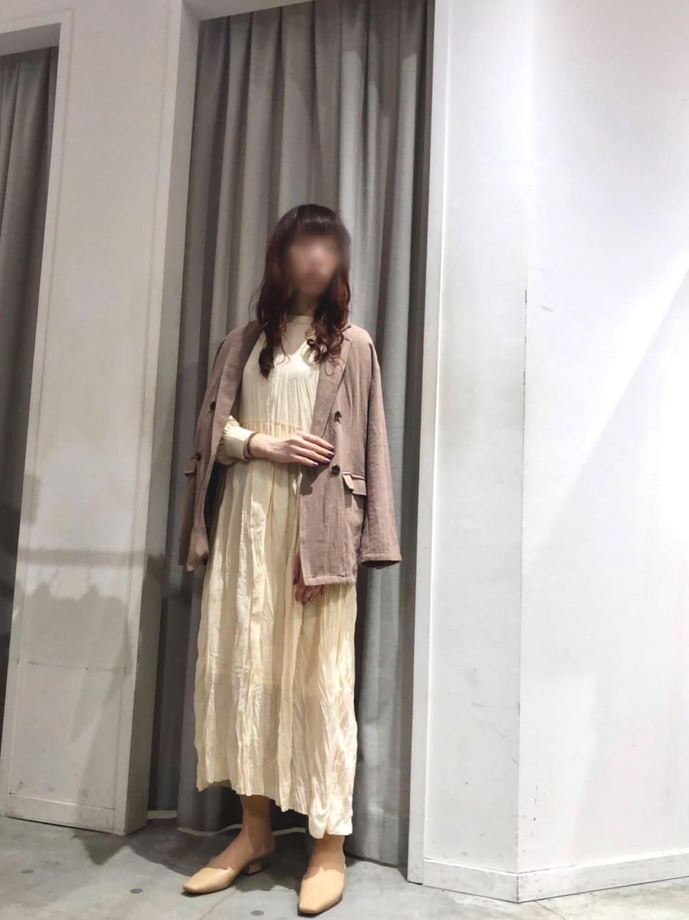 ベージュ系のワンピース、ベージュ系のサンダル、ブラウン系のテーラードジャケットを着用したレディースの春コーディネートの1枚目の写真