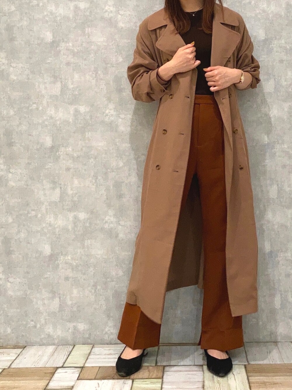 ブラウン系のスラックス、ブラウン系のトレンチコートを着用したレディースの秋コーディネートの1枚目の写真