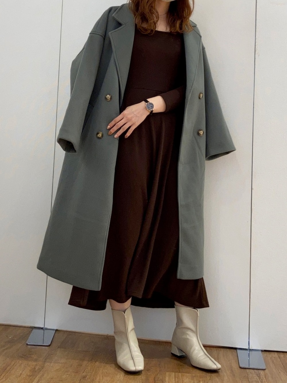 ブラウン系のワンピース、ベージュ系のブーツ、グリーン系のチェスターコートを着用したレディースの秋コーディネートの1枚目の写真