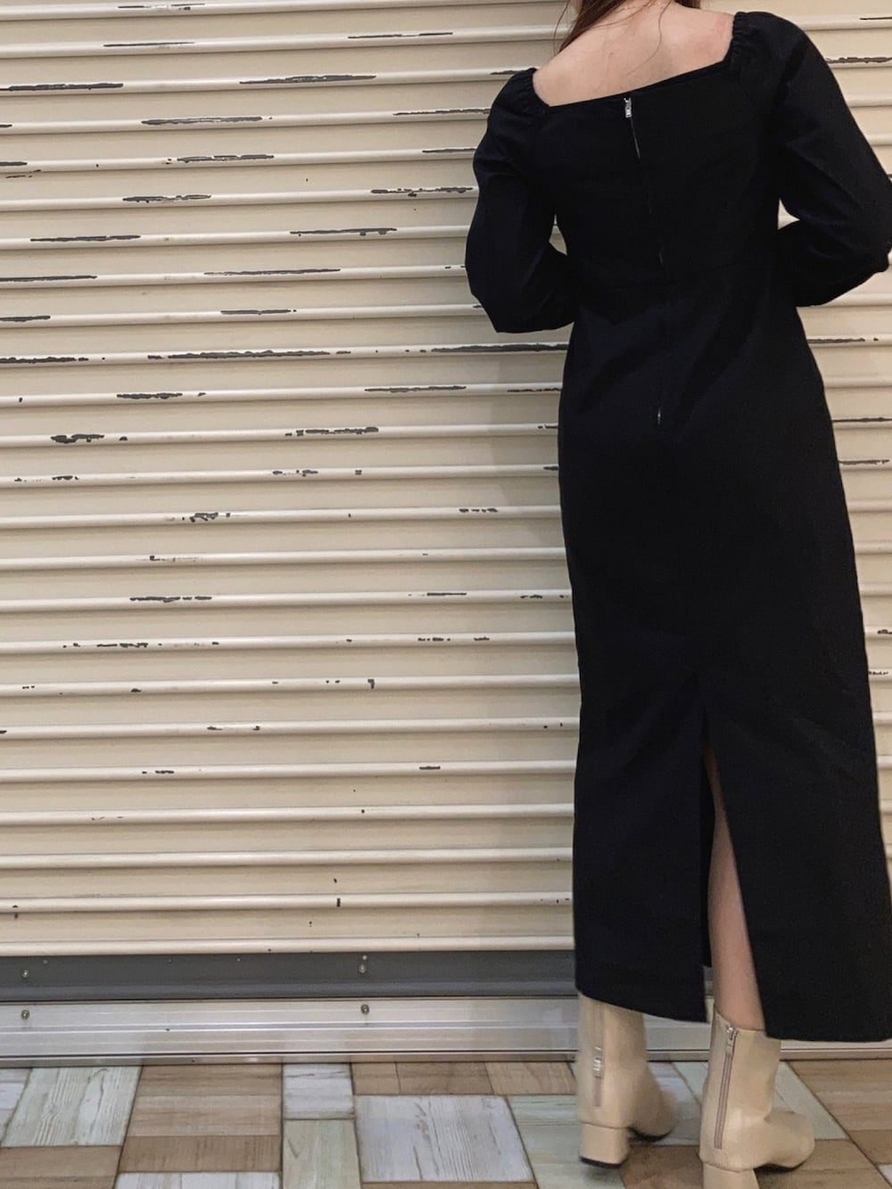 ブラック系のワンピース、ベージュ系のブーツを着用したレディースの秋コーディネートの1枚目の写真