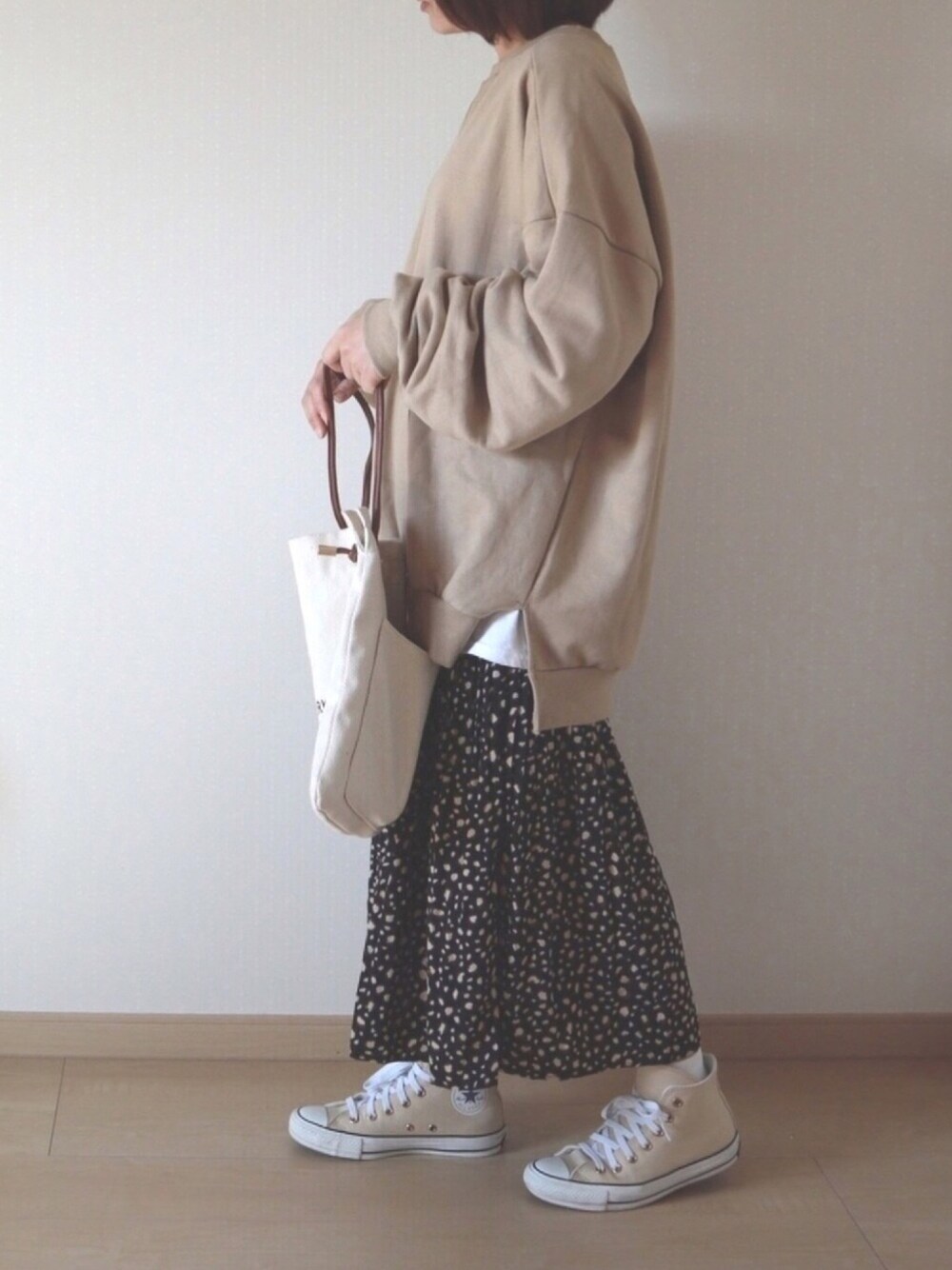 ベージュ系のスウェット、ブラック系のその他パンツ、ホワイト系のショルダーバッグを着用したレディースの秋コーディネートの1枚目の写真