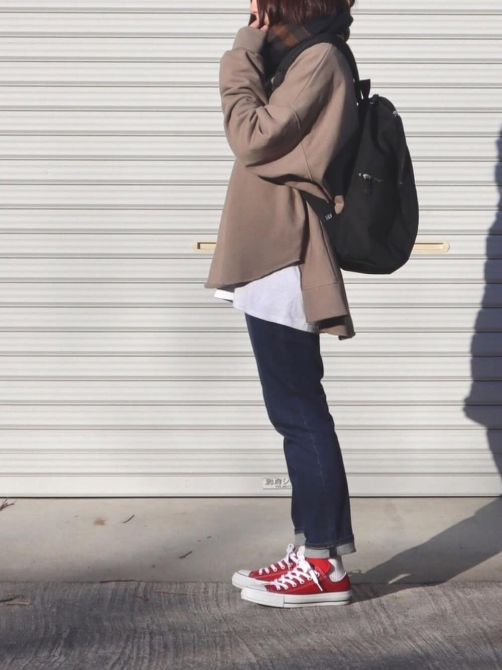 ベージュ系のスウェット、ホワイト系のTシャツ/カットソー、ブラック系のバックパック/リュックを着用したレディースの冬コーディネートの1枚目の写真