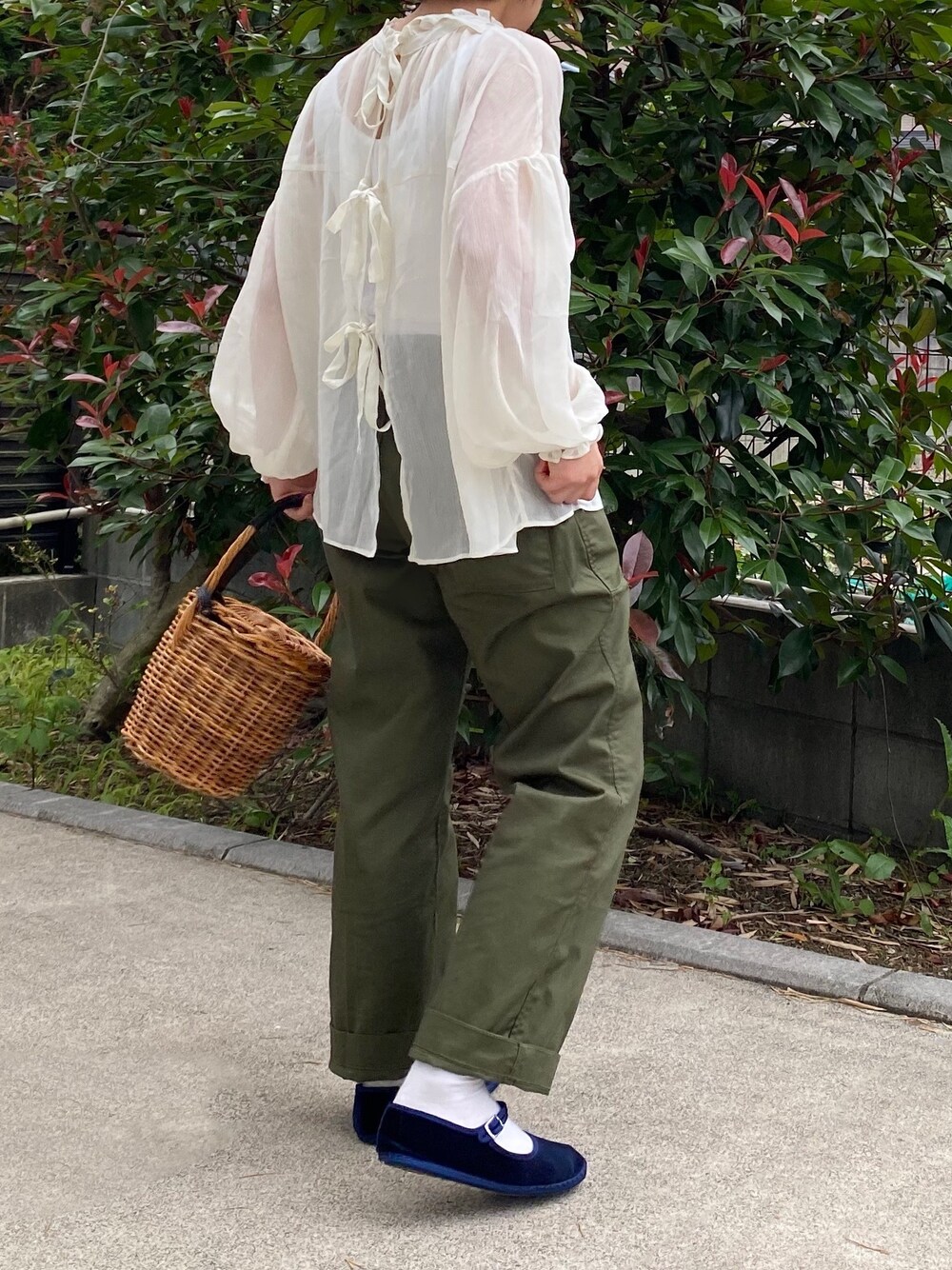 ホワイト系のシャツ/ブラウス、グリーン系のパンツ、ベージュ系のかごバッグを着用したレディースの夏コーディネートの1枚目の写真