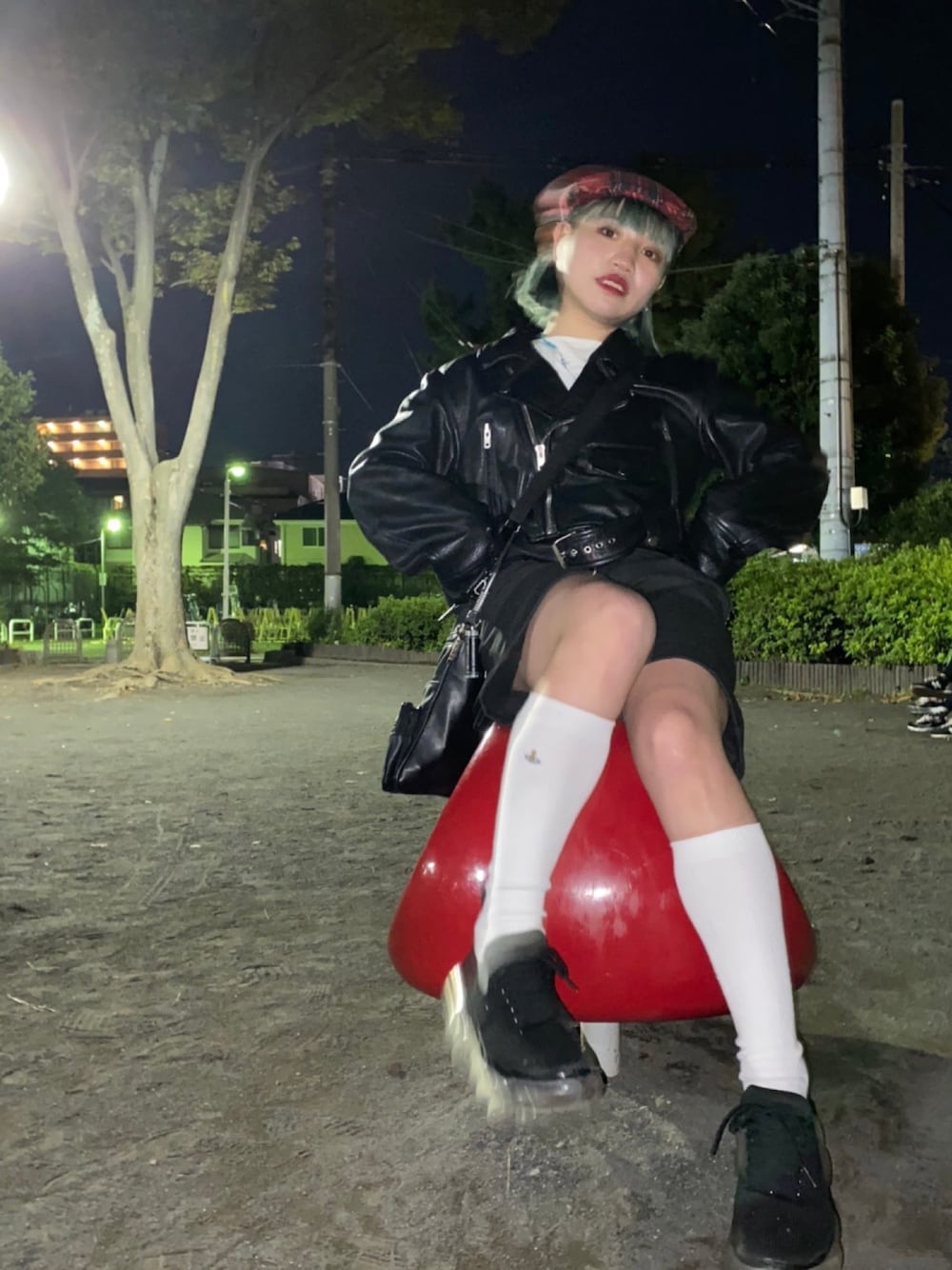 ブラック系のライダースジャケット、ブラック系のスニーカー、レッド系のハンチング/ベレー帽を着用したレディースの秋コーディネートの1枚目の写真