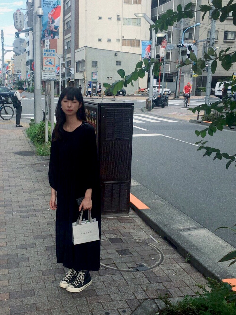 ブラック系のワンピース、ブラック系のスニーカーを着用したレディースの秋コーディネートの1枚目の写真