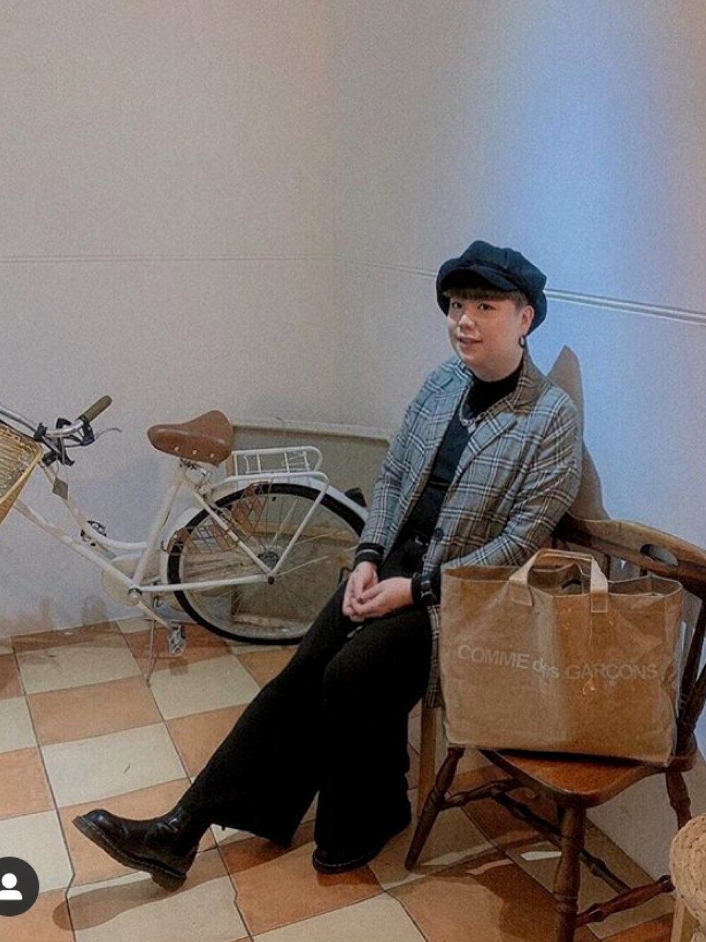 ベージュ系のクラッチバッグ、ブラック系のブーツ、グレー系のキャスケットを着用したメンズの冬コーディネートの1枚目の写真