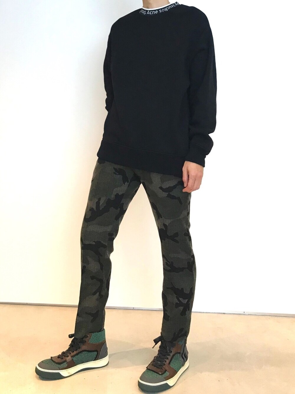 グリーン系のスニーカー、ブラック系のスウェットを着用したメンズの秋コーディネートの1枚目の写真