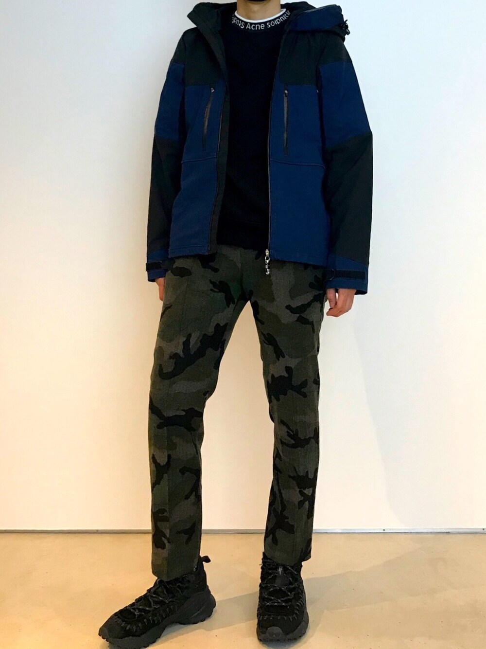 ブルー系のマウンテンパーカー、グリーン系のその他パンツ、ブラック系のスニーカーを着用したメンズの秋コーディネートの1枚目の写真