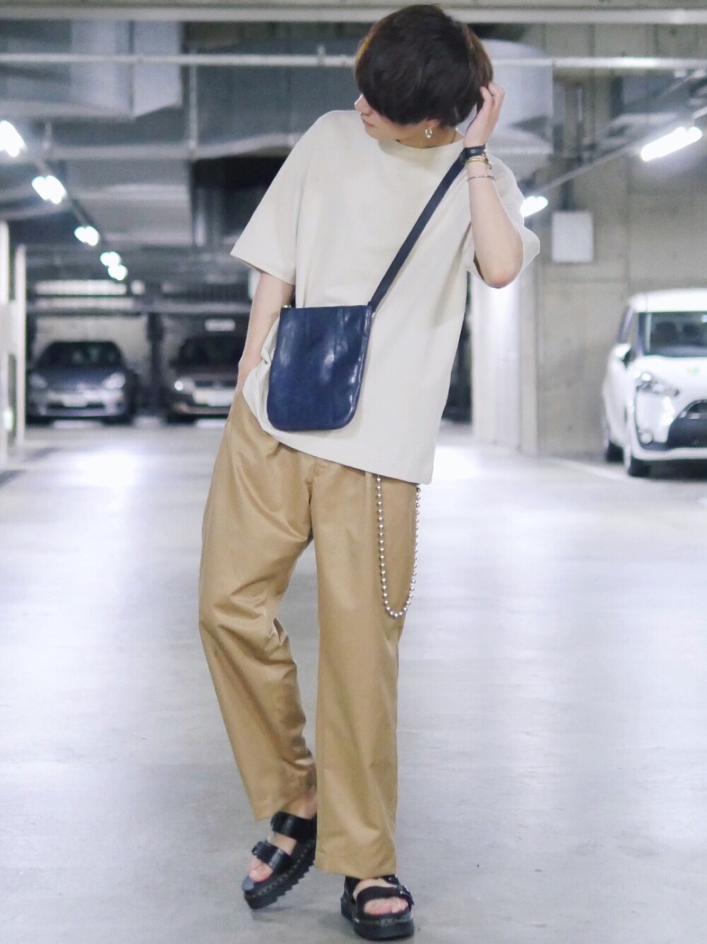 ベージュ系のTシャツ/カットソー、ブルー系のボディバッグ/ウエストポーチ、ベージュ系のスラックスを着用したメンズの春コーディネートの1枚目の写真