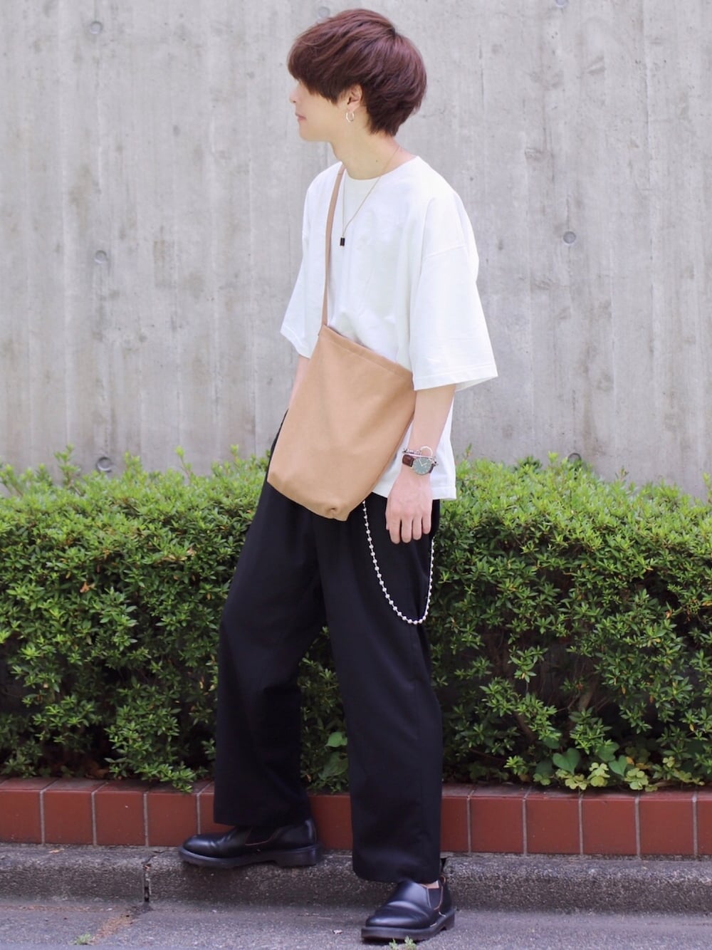 ホワイト系のTシャツ/カットソー、ブラック系のスラックス、ベージュ系のバッグを着用したメンズの夏コーディネートの1枚目の写真