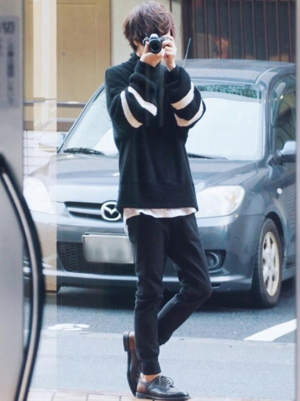 ブラック系のニット/セーター、ホワイト系のTシャツ/カットソー、ブラック系のデニムパンツを着用したメンズの冬コーディネートの1枚目の写真