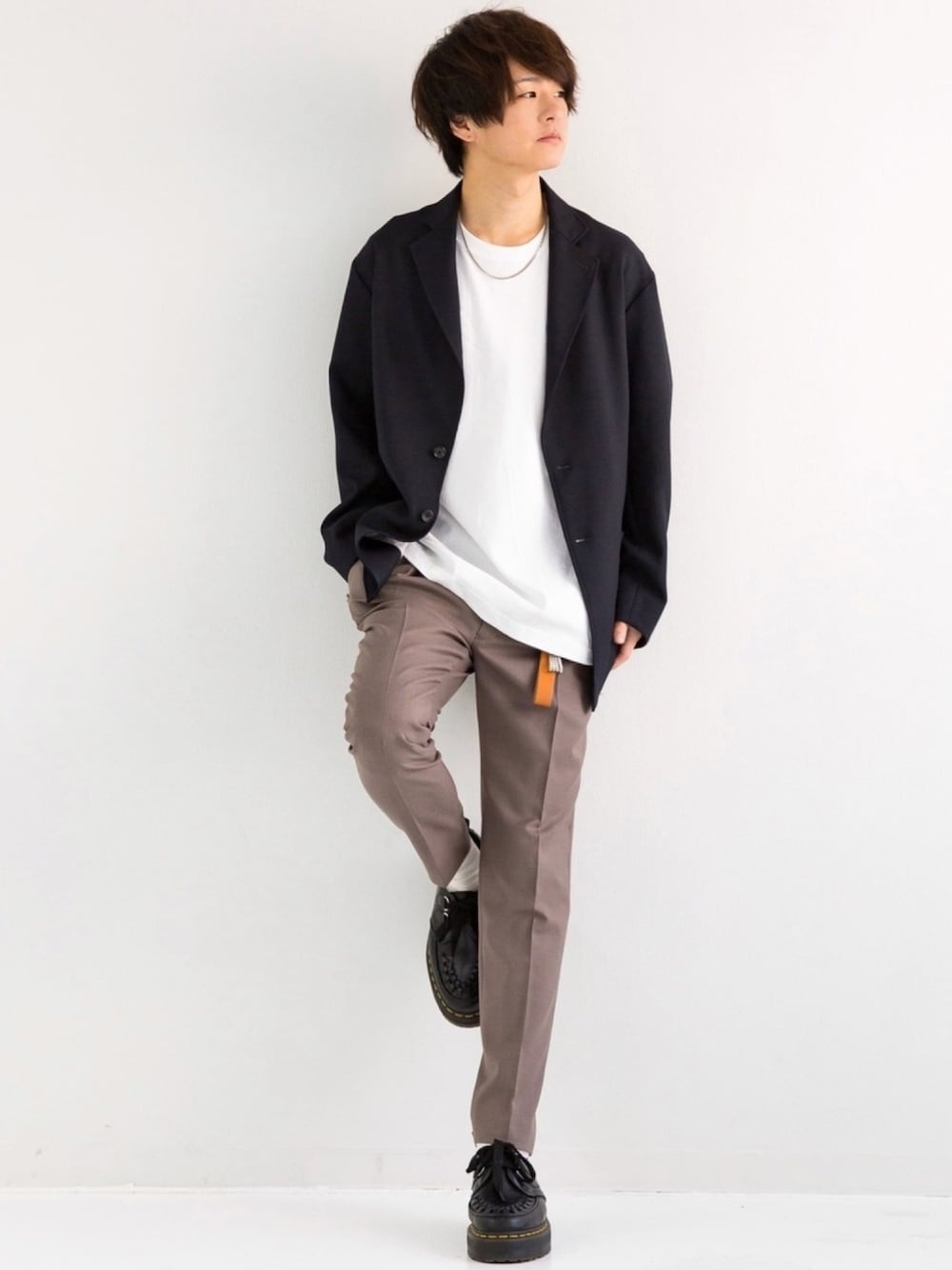 ブルー系のテーラードジャケット、ホワイト系のTシャツ/カットソー、ブラウン系のスラックスを着用したメンズの冬コーディネートの1枚目の写真