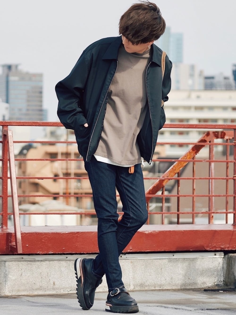 ブラック系のブルゾン、ブラウン系のTシャツ/カットソー、ホワイト系のタンクトップを着用したメンズの春コーディネートの1枚目の写真